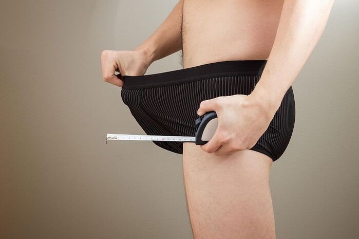 мъж със сантиметър се подготвя за упражнения за уголемяване на пениса